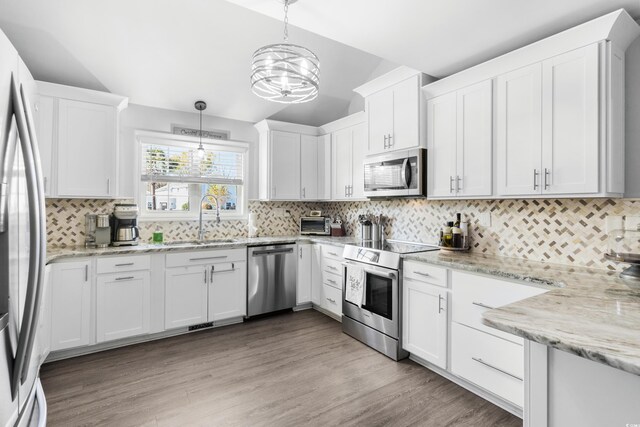 160 Shipmaster Ave, Pawleys Island, SC 29585 - kitchen with appliances with stainless steel finishes, a chandelier, a sink, decorative backsplash, and white cabinets
