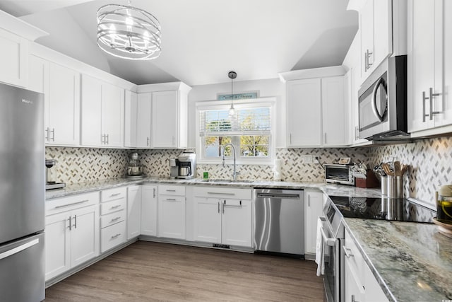 160 Shipmaster Ave, Pawleys Island, SC 29585 - kitchen featuring appliances with stainless steel finishes, a sink, lofted ceiling, white cabinetry, and decorative backsplash