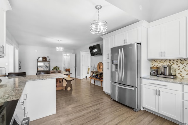 160 Shipmaster Ave, Pawleys Island, SC 29585 - kitchen featuring stainless steel refrigerator with ice dispenser, a chandelier, white cabinetry, tasteful backsplash, and light wood-style floors