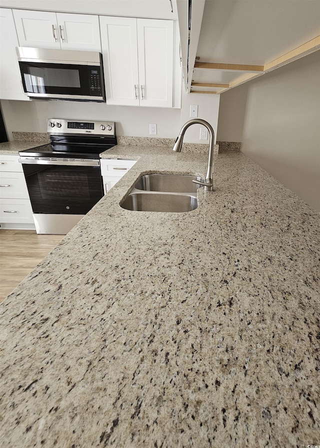 703 S 1st Ave S Unit 34D, North Myrtle Beach, SC 29582 - kitchen featuring stainless steel appliances, a sink, light stone countertops, and white cabinetry