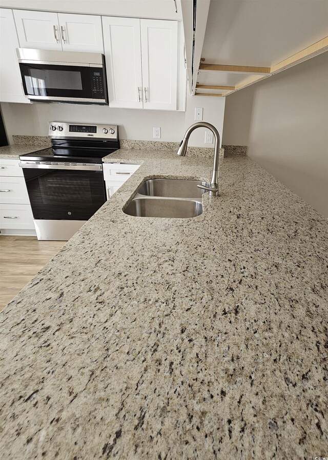 703 S 1st Ave S Unit 34D, North Myrtle Beach, SC 29582 - kitchen featuring stainless steel appliances, a sink, light stone countertops, and white cabinetry
