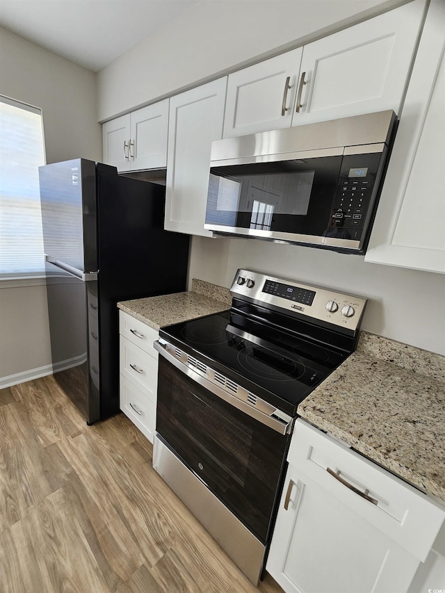 703 S 1st Ave S Unit 34D, North Myrtle Beach, SC 29582 - kitchen featuring stainless steel appliances, light wood-style flooring, white cabinetry, and light stone countertops