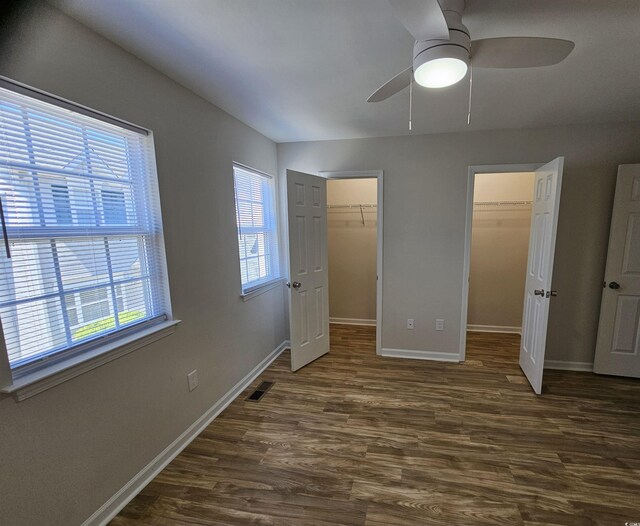703 S 1st Ave S Unit 34D, North Myrtle Beach, SC 29582 - unfurnished bedroom featuring wood finished floors, baseboards, a spacious closet, ensuite bathroom, and a ceiling fan