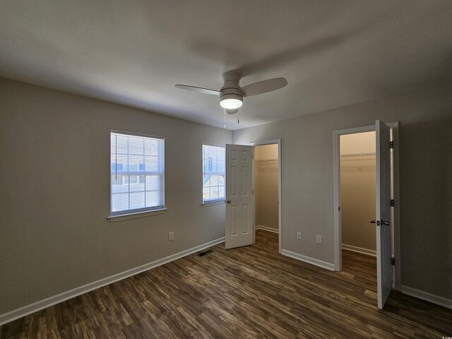 703 S 1st Ave S Unit 34D, North Myrtle Beach, SC 29582 - unfurnished bedroom featuring dark wood-style flooring, a spacious closet, baseboards, and ceiling fan