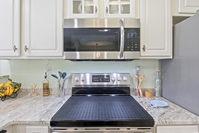2180 Waterview Dr Unit 733, North Myrtle Beach, SC 29582 - kitchen view of appliances with stainless steel finishes, white cabinets, glass insert cabinets, and light stone counters