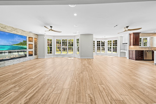 unfurnished living room with light wood finished floors, visible vents, and ceiling fan