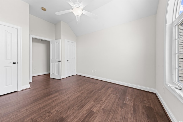unfurnished bedroom with dark wood-type flooring, baseboards, vaulted ceiling, and ceiling fan