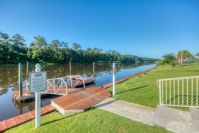 dock area with a lawn and a water view