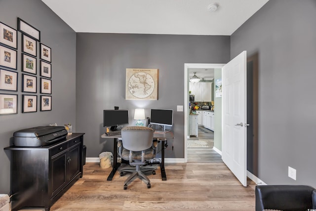 office featuring light wood-type flooring and baseboards