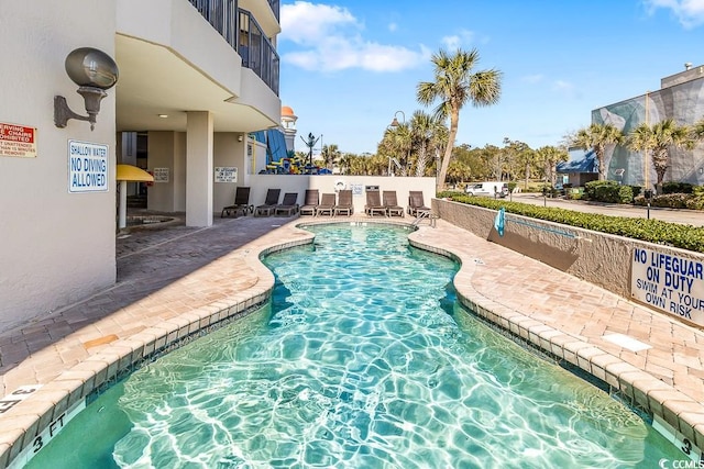 community pool with a patio and fence