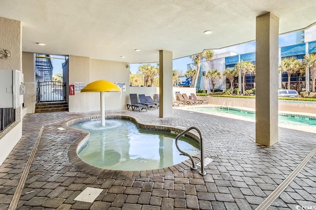 community pool with a patio and a gate