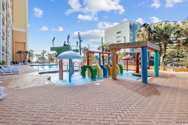 6900 N Ocean Blvd Unit 404, Myrtle Beach, SC 29572 - view of playground with fence, a water play area, a patio, and a community pool