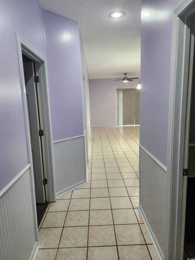 6204 Sweetwater Blvd Unit 6204, Murrells Inlet, SC 29576 - hall featuring light tile patterned flooring, a textured ceiling, and wainscoting