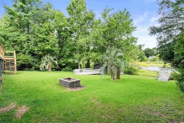 532 Medcalf Dr SW, Sunset Beach, NC 28468 - view of yard featuring an outdoor fire pit, a deck with water view, and stairway