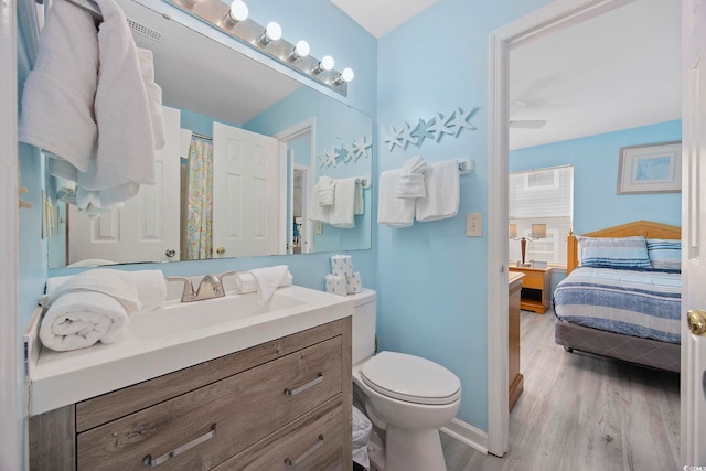 412 Seaside Dr S, Surfside Beach, SC 29575 - full bathroom featuring toilet, connected bathroom, wood finished floors, vanity, and baseboards
