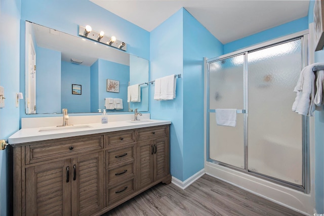 412 Seaside Dr S, Surfside Beach, SC 29575 - bathroom featuring wood finished floors, a stall shower, double vanity, and baseboards