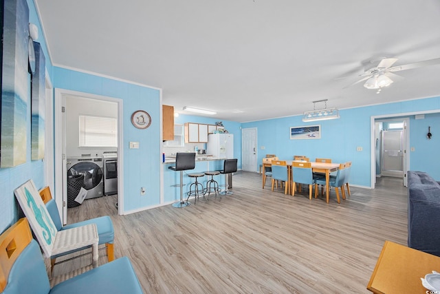 412 Seaside Dr S, Surfside Beach, SC 29575 - living room featuring separate washer and dryer, light wood finished floors, a ceiling fan, and plenty of natural light