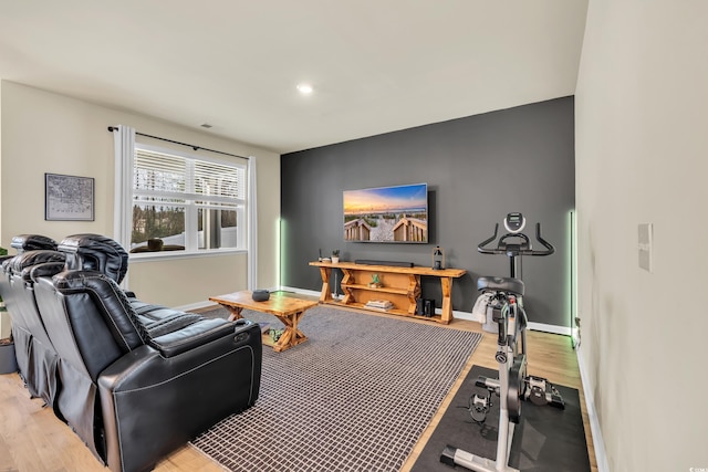 exercise room featuring light wood-style floors, baseboards, and recessed lighting