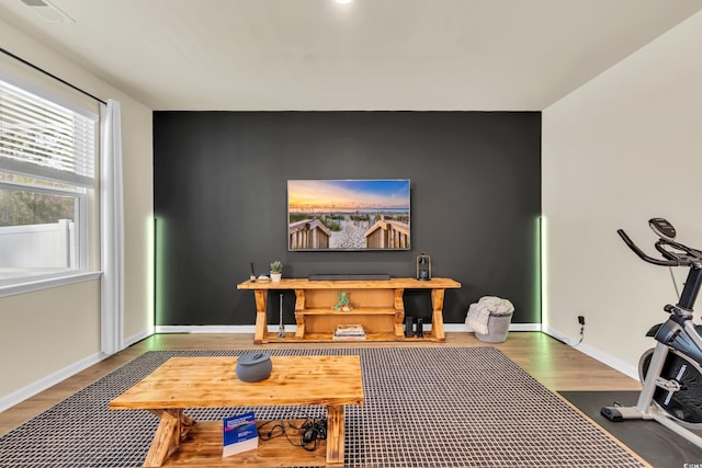 exercise area with wood finished floors and baseboards