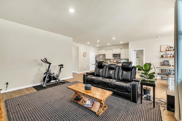 living area featuring light wood-type flooring, baseboards, and recessed lighting