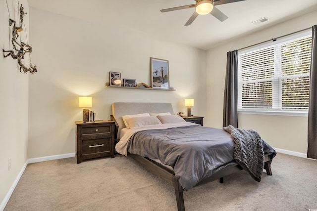 bedroom with light carpet, baseboards, and a ceiling fan