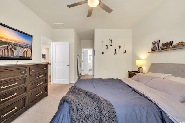 bedroom featuring light colored carpet, ensuite bath, and ceiling fan