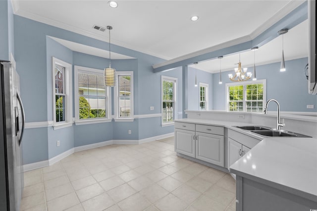 kitchen with an inviting chandelier, crown molding, a sink, and freestanding refrigerator