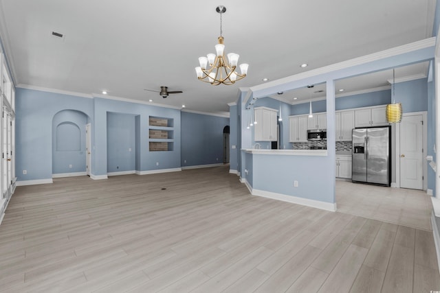 kitchen with open floor plan, arched walkways, white cabinetry, appliances with stainless steel finishes, and recessed lighting