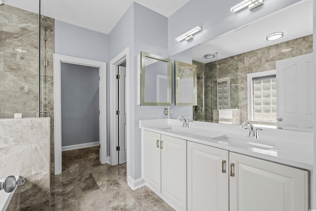 bathroom with baseboards, a sink, double vanity, and a stall shower