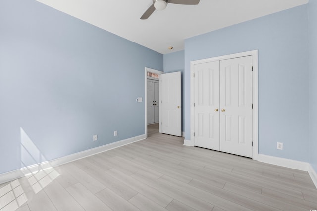 unfurnished bedroom with light wood-style floors, a closet, baseboards, and ceiling fan