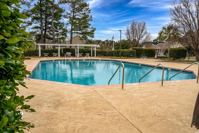 pool with a pergola, a patio, and fence