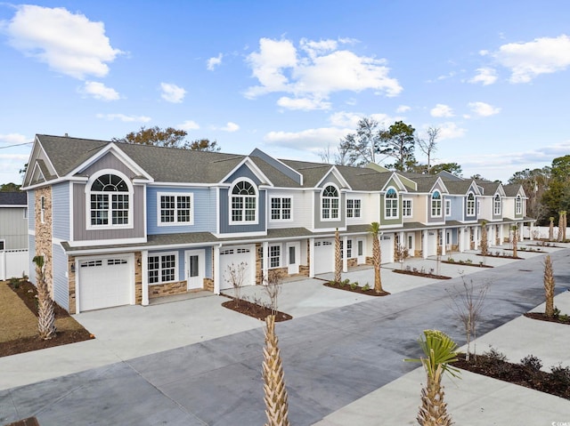 904 62nd Ave N Unit E, Myrtle Beach, SC 29572 - view of property featuring a residential view, an attached garage, driveway, and stone siding
