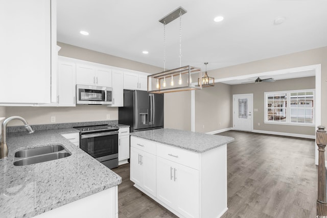 904 62nd Ave N Unit E, Myrtle Beach, SC 29572 - kitchen with a kitchen island, decorative light fixtures, light stone countertops, a sink, and stainless steel appliances