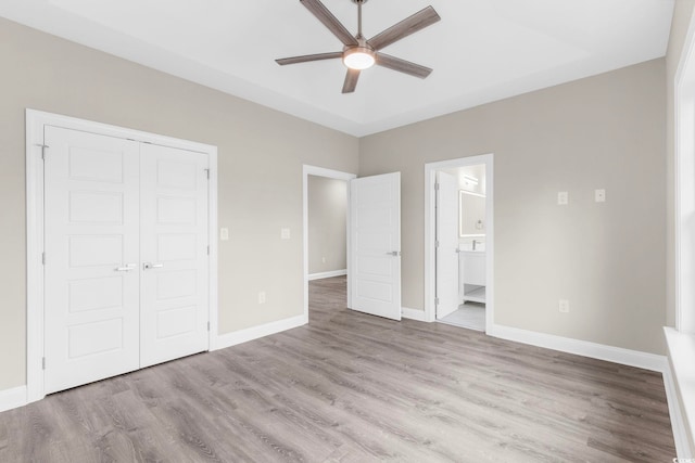 904 62nd Ave N Unit E, Myrtle Beach, SC 29572 - unfurnished bedroom with connected bathroom, a ceiling fan, baseboards, wood finished floors, and a closet
