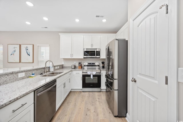 201-E Madison Ct, Myrtle Beach, SC 29577 - kitchen featuring stainless steel appliances, a sink, light wood-style floors, white cabinets, and recessed lighting