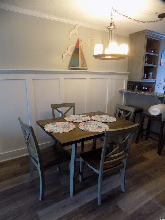 305 N Hillside Dr N Unit 103, North Myrtle Beach, SC 29582 - dining area with crown molding, a decorative wall, a wainscoted wall, and dark wood-style flooring