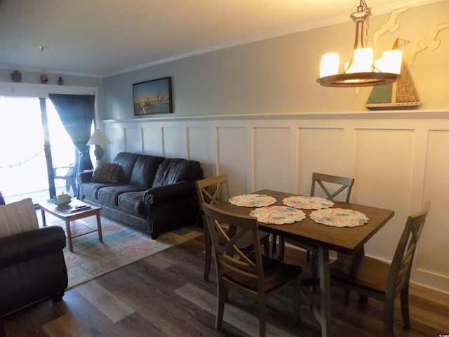 305 N Hillside Dr N Unit 103, North Myrtle Beach, SC 29582 - dining area featuring a chandelier, dark wood-style flooring, wainscoting, crown molding, and a decorative wall