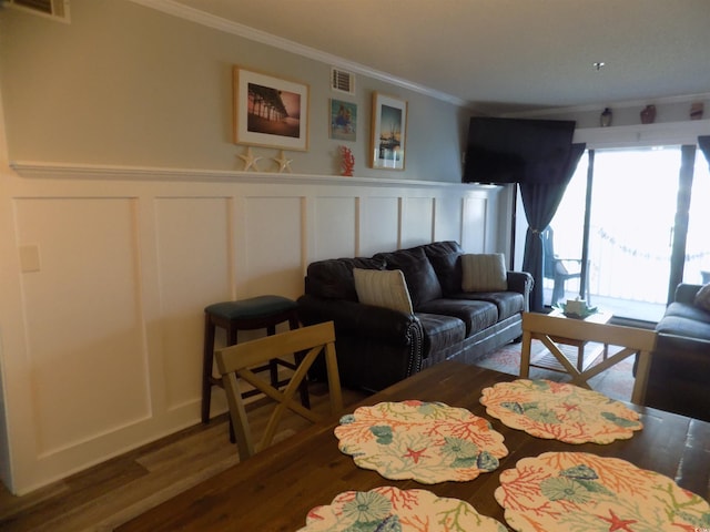305 N Hillside Dr N Unit 103, North Myrtle Beach, SC 29582 - living area with ornamental molding, wood finished floors, a decorative wall, and wainscoting