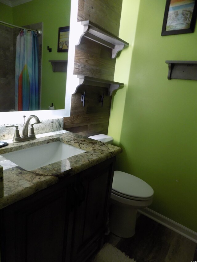 305 N Hillside Dr N Unit 103, North Myrtle Beach, SC 29582 - bathroom with vanity, toilet, a shower with curtain, baseboards, and wood finished floors