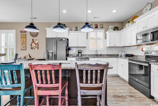 kitchen featuring backsplash, stainless steel appliances, visible vents, and a sink