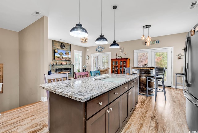 kitchen with light wood-type flooring, visible vents, and a healthy amount of sunlight