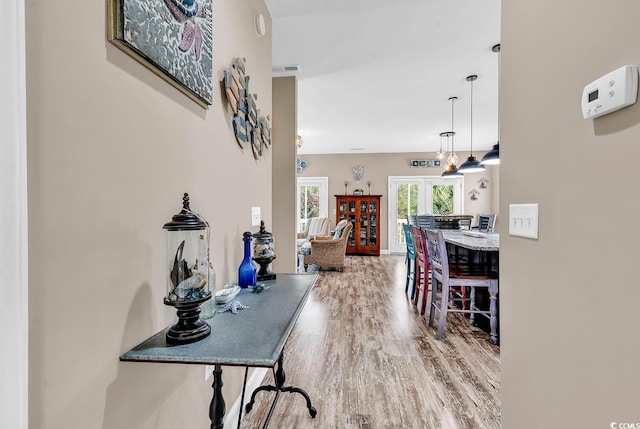 hall with wood finished floors and french doors