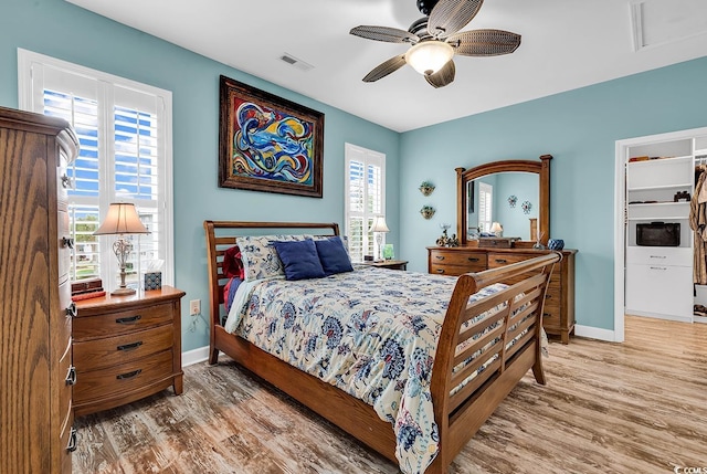 bedroom with visible vents, baseboards, wood finished floors, and ceiling fan