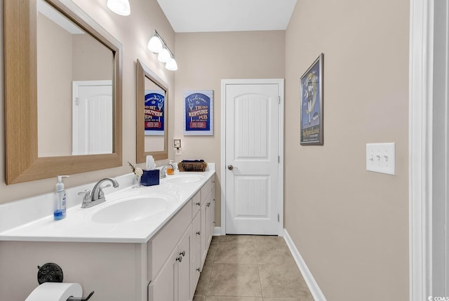 full bath with double vanity, tile patterned floors, baseboards, and a sink