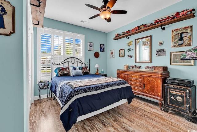 bedroom featuring a ceiling fan, wood finished floors, and visible vents