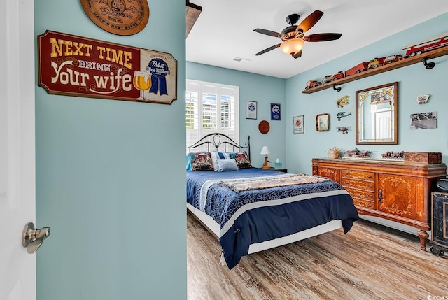 bedroom featuring wood finished floors, visible vents, and ceiling fan