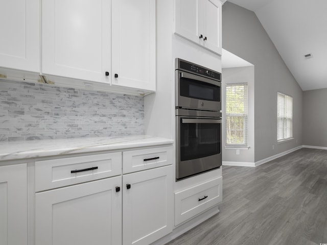 4854 Meadowsweet Dr Unit 1909, Myrtle Beach, SC 29579 - kitchen featuring double oven, lofted ceiling, backsplash, white cabinets, and light wood-style flooring