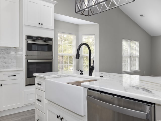 4854 Meadowsweet Dr Unit 1909, Myrtle Beach, SC 29579 - kitchen featuring stainless steel appliances, tasteful backsplash, light stone counters, white cabinetry, and lofted ceiling