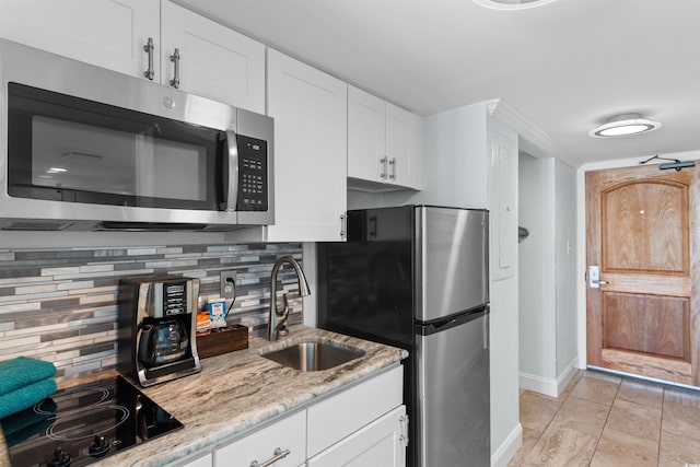 9550 Shore Dr Unit 1026, Myrtle Beach, SC 29572 - kitchen featuring stainless steel appliances, a sink, baseboards, decorative backsplash, and white cabinetry