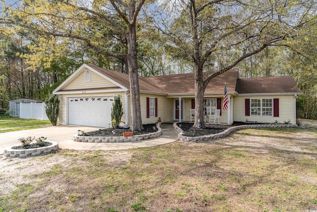 ranch-style home featuring a garage, fence, driveway, and a front lawn